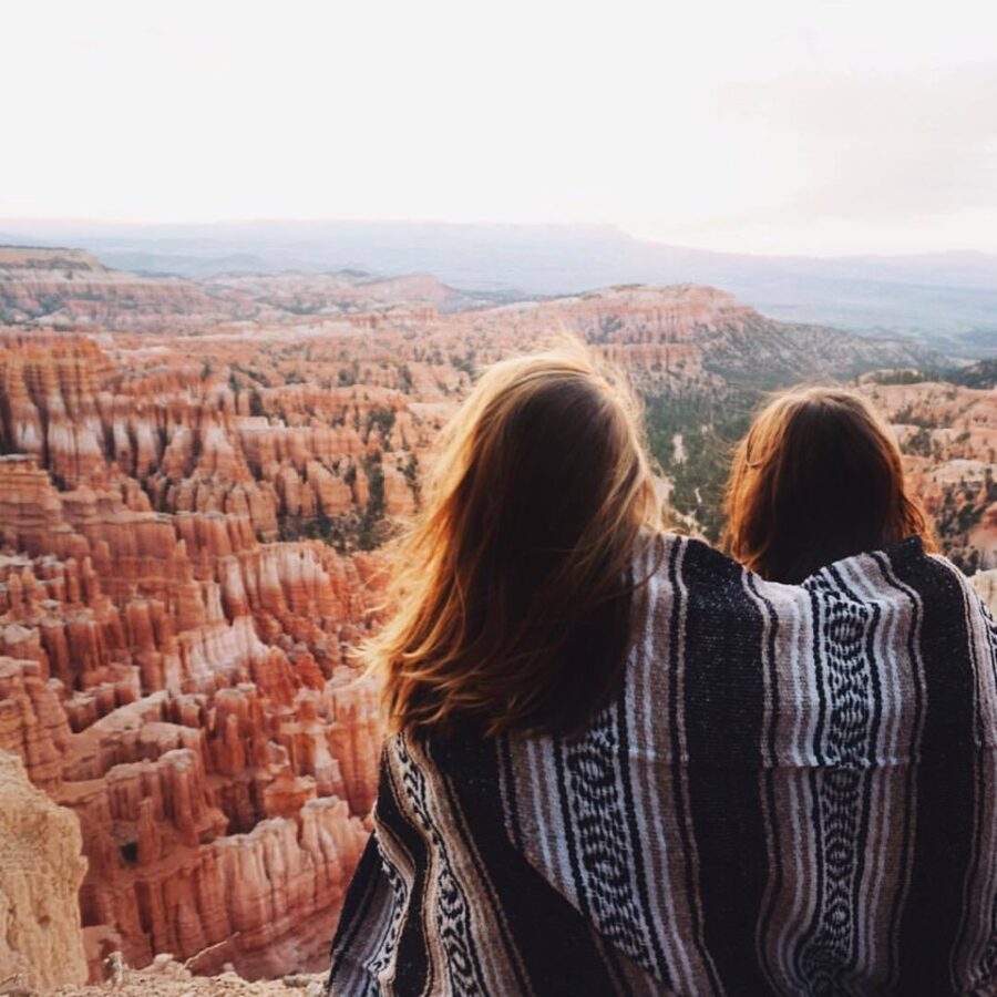 Two women watching sunrise at Bryce with warm blanket